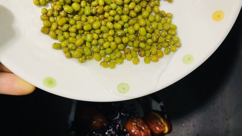 红枣黑米粥,把洗好的绿豆倒入电饭煲;