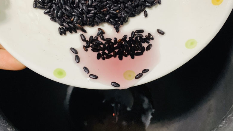 红枣黑米粥,把洗净的黑米倒入电饭煲;