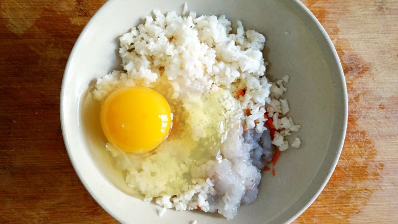 鲜虾饼,将一颗<a style='color:red;display:inline-block;' href='/shicai/ 9'>鸡蛋</a>打进虾泥,马蹄碎和胡萝卜碎中。