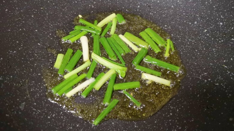 黄瓜木耳炒鸡蛋,炒锅内继续倒油烧热,下入小葱炒香。