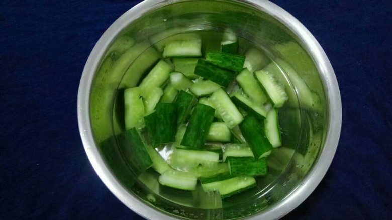 酸辣黄瓜条,冲洗好的黄瓜捞出,将黄瓜水份完全挤出放入容器中。(挤的越干黄越脆,可把黄瓜放进纱布中挤出水份)