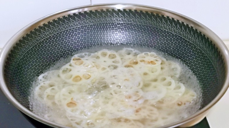 醋溜藕片,将藕片焯水,锅中加入水烧开,下藕片,加入少许盐,煮熟捞出。