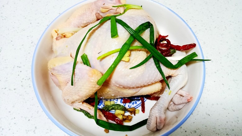 盐水鸡,将鸡里外均匀涂上盐,放入<a style='color:red;display:inline-block;' href='/shicai/ 37'>姜</a>、小葱、辣椒冰箱冷藏腌制2小时