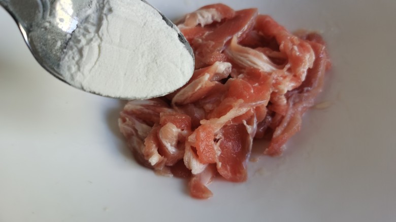 黄瓜木耳炒肉,再加入适量的湿淀粉抓匀,最后加入一勺食用油抓匀,利用肉片腌制的时间,可以把蔬菜切一下。