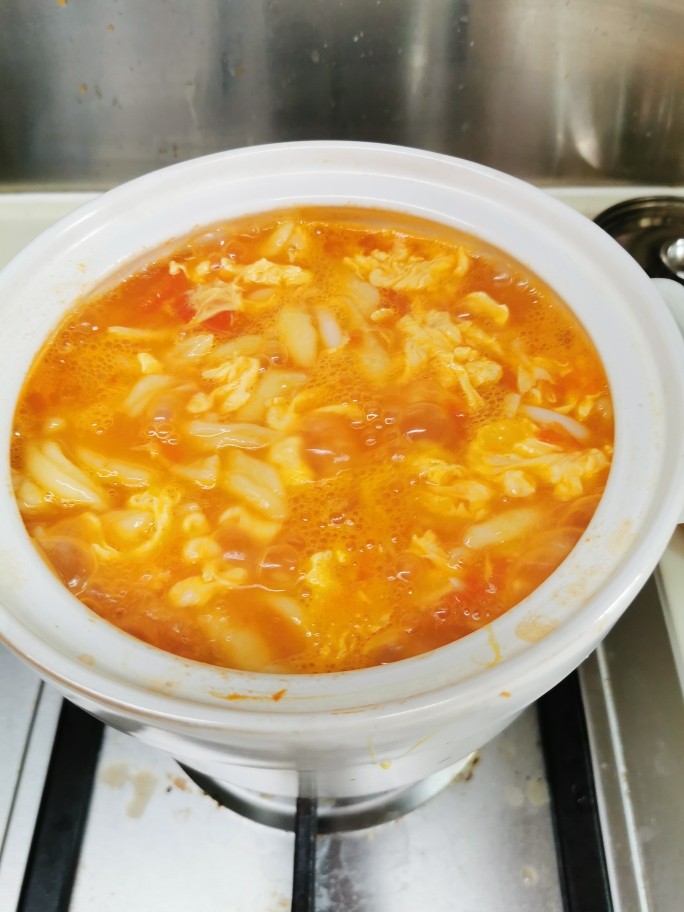 香浓蕃茄面汤,关小火,慢慢地把剩下的鸡蛋液浇进去,勺子轻轻推动一下,这样子煮蛋花又滑又漂亮!