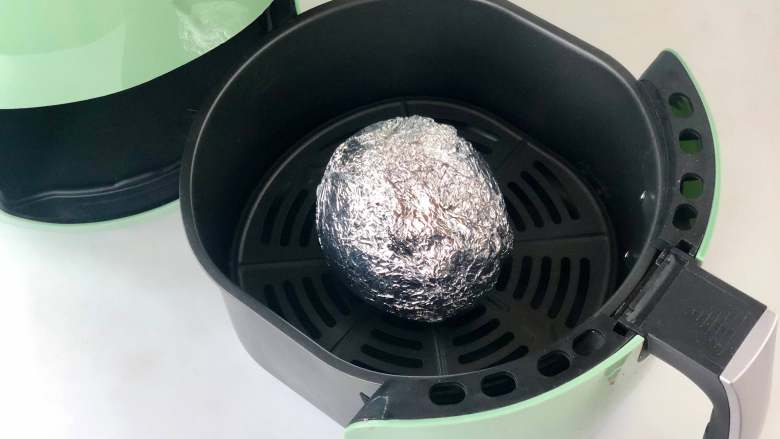 解锁梨子新吃法!热气腾腾,格外治愈,把包好的梨子放入炸锅,推入机器中。