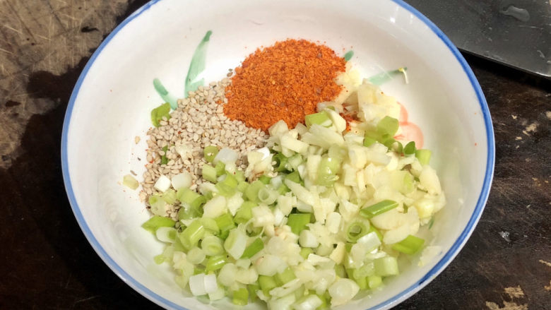 千里莺啼绿映红➕凉拌三彩豆皮,取小碗,加上葱蒜末,一汤匙白芝麻,一汤匙辣椒粉