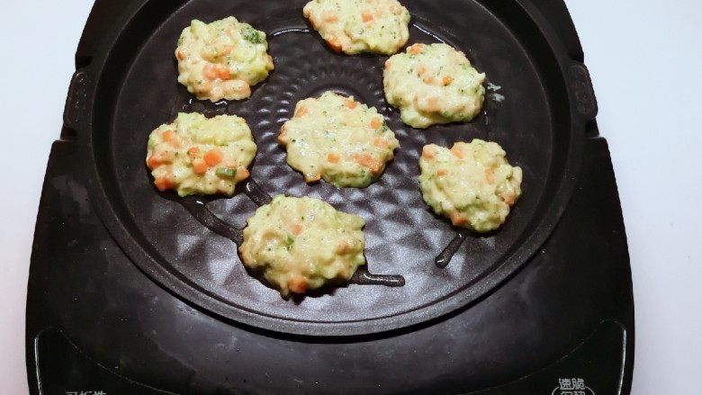 鲜虾饼,煎烤机刷一层油 预热 用勺子将虾肉糊 放入煎烤机 压成小饼