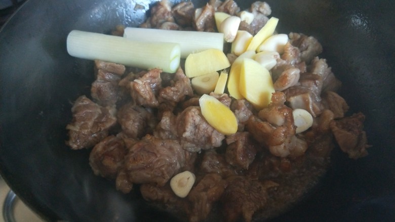 红焖牛肉,炒牛肉,加入葱姜蒜,炒均匀。