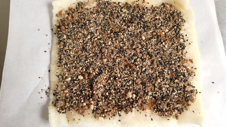 红糖麻糍,煎好后的糯米片取出来,上面铺上混合好的红糖芝麻。