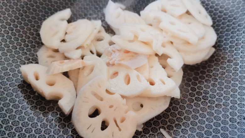 醋溜藕片,油热后,将沥干水分的藕片倒入锅中迅速翻炒