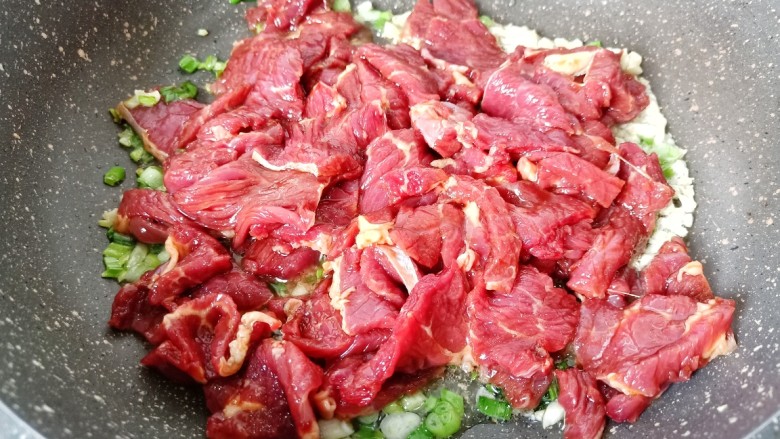 爆炒牛肉丝,把腌制好的牛肉放入锅里,用铲快速将牛肉炒散。