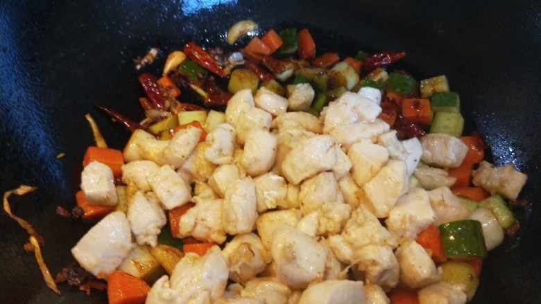 麻辣干锅鸡,辣椒块炒均匀,倒入鸡丁。