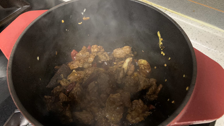 红焖牛肉,牛肉表面变色后放入一小勺老抽,均匀上色