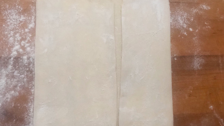 美味蝴蝶酥,包裹好的面片,均匀擀开,不要用力过大,左右对折,然后再对折,完成一次四折。