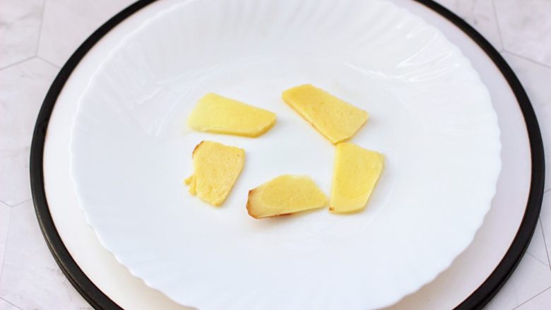 香辣酱蒸鲈鱼,蒸盘里先铺上<a style='color:red;display:inline-block;' href='/shicai/ 37'>姜</a>片,这样在蒸鱼的过程中,鱼会受热均匀,而且不会把鱼皮粘掉。