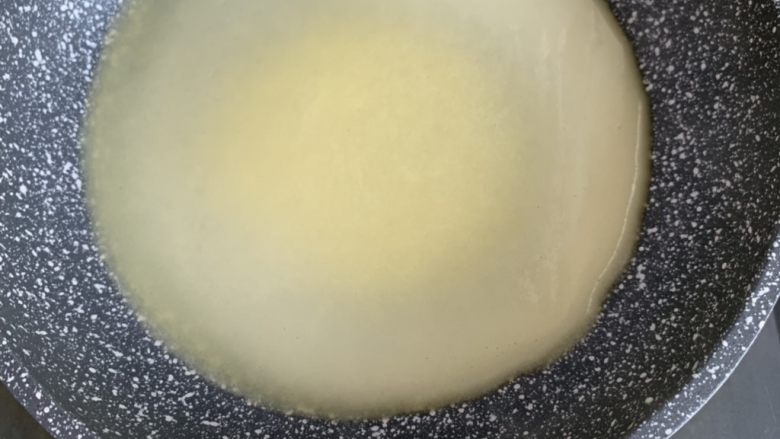 芒果千层蛋糕,我用的是20cm的平底不粘锅,一勺面糊由中间放入,轻轻晃动平底锅,让面糊均匀摊开,全程小火即可,面糊逐渐凝固呈半透明状,不要翻面,单面烙熟即可,离火,我用硅胶刀轻轻拨开四周很容易就取下来了,取下来的饼可以叠放在一起,不会粘连的。