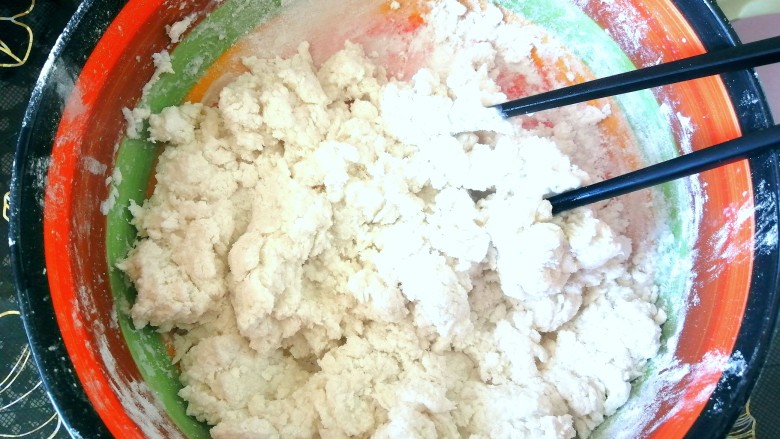 红糖麻糍,把面倒入盆中,用温开水先搅成絮状。