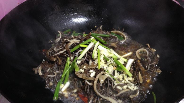 爆炒牛肚,转大火,倒入肚丝、剩下的一半葱段、蒜碎迅速翻匀