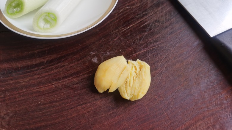 牛肉炖豆腐,大葱切成葱段,生姜用刀拍散。
