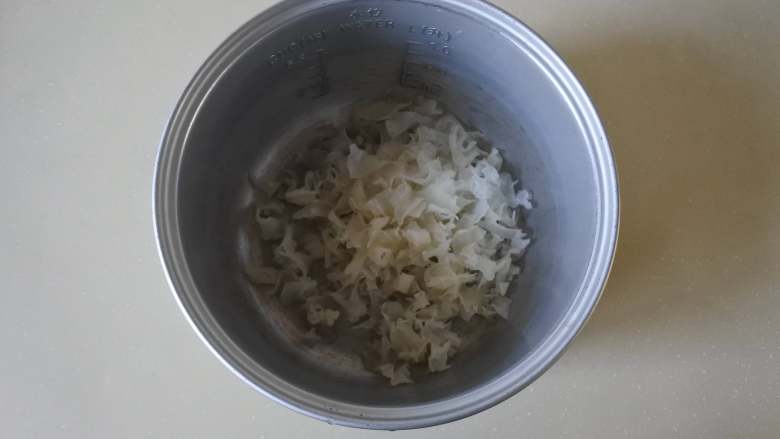 润肺止咳又能增强免疫力的银耳雪梨百合甜汤,把银耳放入电饭锅里,加水,煮开。开锅后继续煲煮50分钟