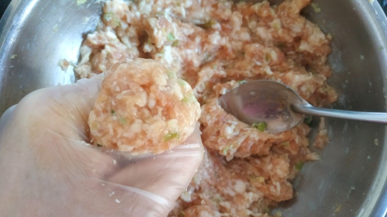 冬瓜肉丸汤,带手套,抓一把肉馅从虎口挤出,然后用勺子舀到锅中,这样做出的丸子圆滑