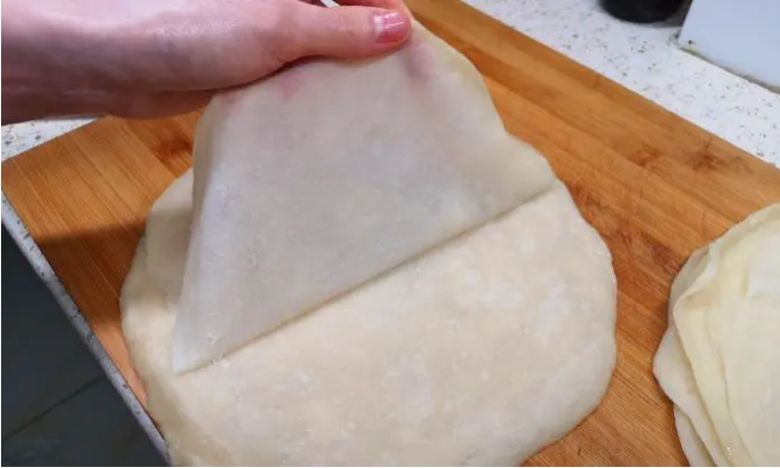 猪肉火烧,锅内加水,将面皮放在盘子内,放入锅中蒸十分钟。面饼蒸熟后取出,把面皮一张张地揭开。