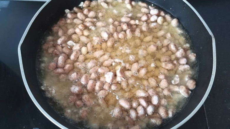 多味花生,倒进去先不要搅,等稍微炸一会再轻轻的搅动,全程用小火炸