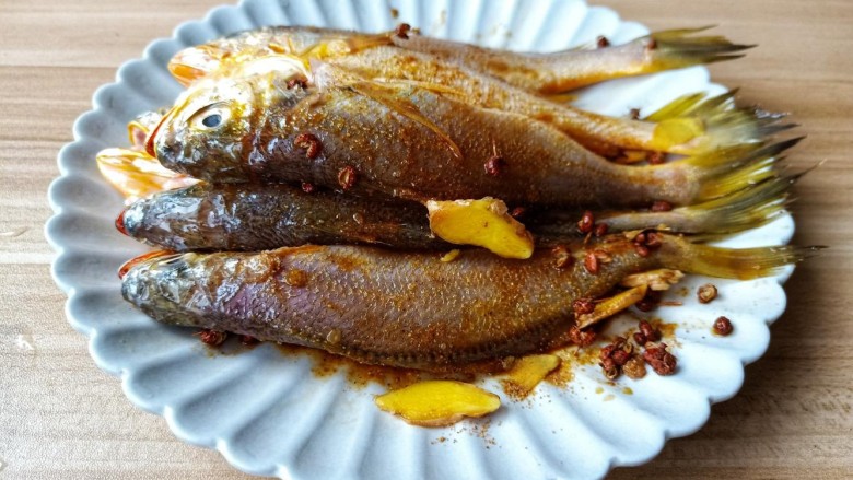 酥炸小黄鱼,轻轻抓鱼,让调味料裹满鱼身,腌制15分钟入味。
