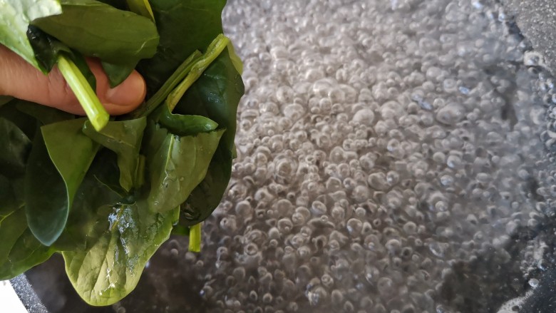 菠菜拌花生米,锅中宽水烧开,下入菠菜。