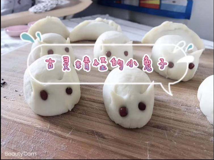 超萌兔兔芝麻包,小剂子捏成圆形,然后一头按压成小兔子身体状,用厨房剪刀剪出两只可爱的耳朵,用干净的红豆装饰眼睛部分。
