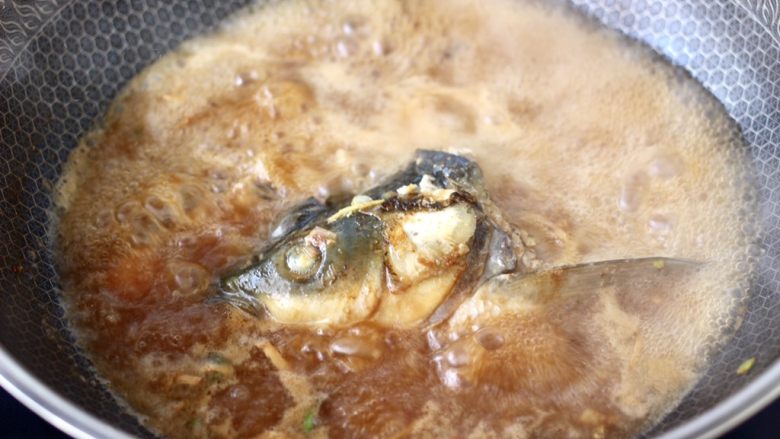 炖草鱼,大火继续炖煮10分钟左右,看见锅中汤汁浓稠时。