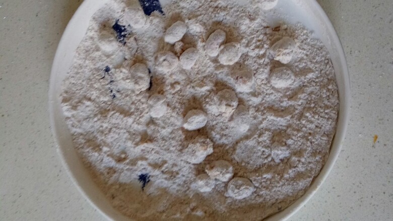 多味花生,晃动盘子,使花生米裹均匀面粉,分次少量裹面粉