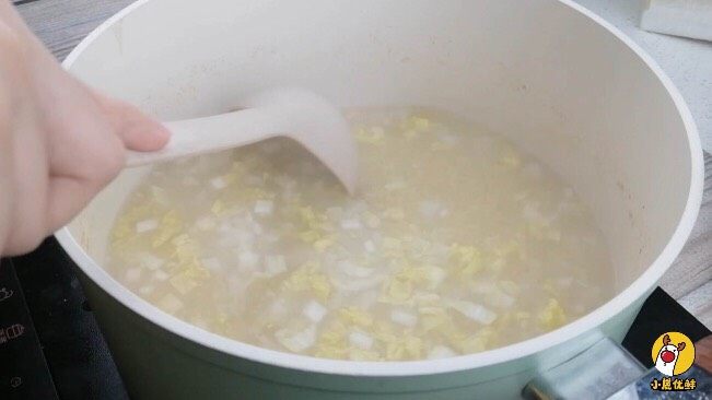 银鳕鱼山药粥,娃娃菜倒入小米粥搅拌均匀,熬煮10min。
