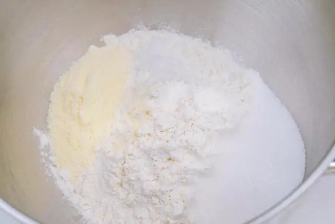 脆底蜂蜜小面包,在搅拌缸中倒入225g高筋面粉和50g低筋面粉。因为这款面包不是吐司,并不需要一片一片的拉丝效果,也不需要特别大的膨发体积,所以在高筋面粉里加一定比例低筋面粉,可以让面包组织更松软。