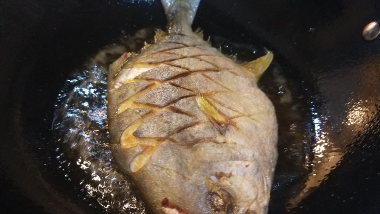 炖草鱼,锅中倒入适量油烧热,炸制两面金黄捞出来控油。