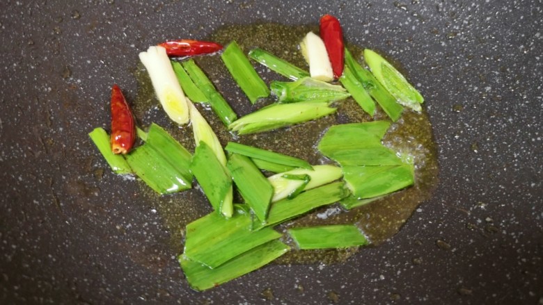 春笋炒肉,锅底留余油,下入蒜苗和干红辣椒炒香。