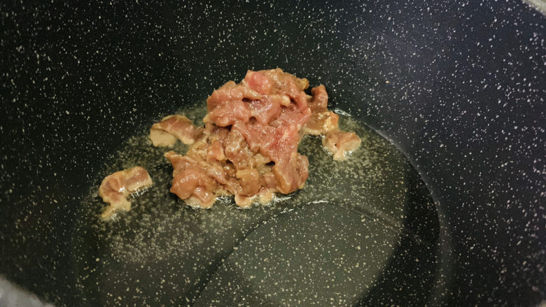 莴笋炒牛肉,把腌制好的牛肉先放入锅里;