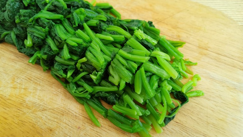 菠菜拌花生米,攥干菠菜中的水分,然后切成小一点的菠菜段。