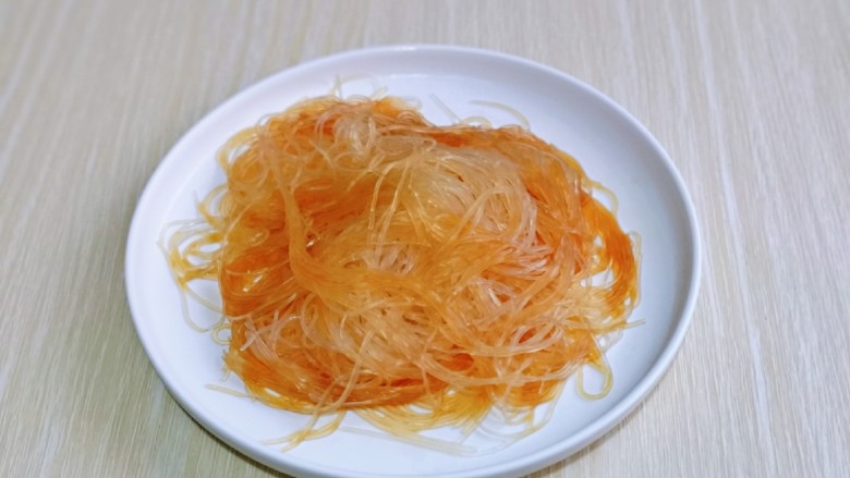 蒜蓉蒸大虾,泡软的粉丝放入盘中,加入1小勺生抽拌均匀。