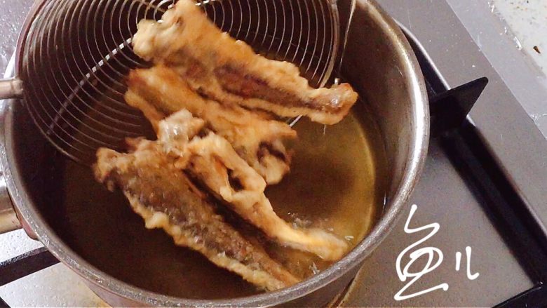 酥炸小黄鱼,油再次烧至四成热,放入鱼复炸约10秒钟