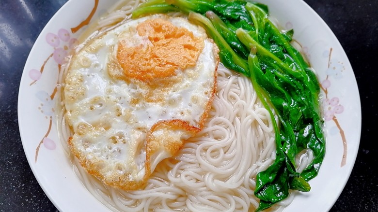 菠菜鸡蛋面,将面捞出放入容器,荷包蛋和菠菜放在上面