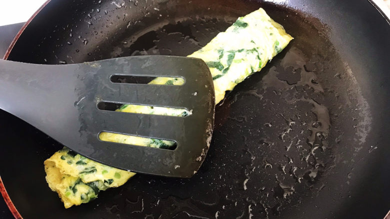菠菜蛋卷,卷好后用铲子轻轻下压,使蛋卷更紧实;