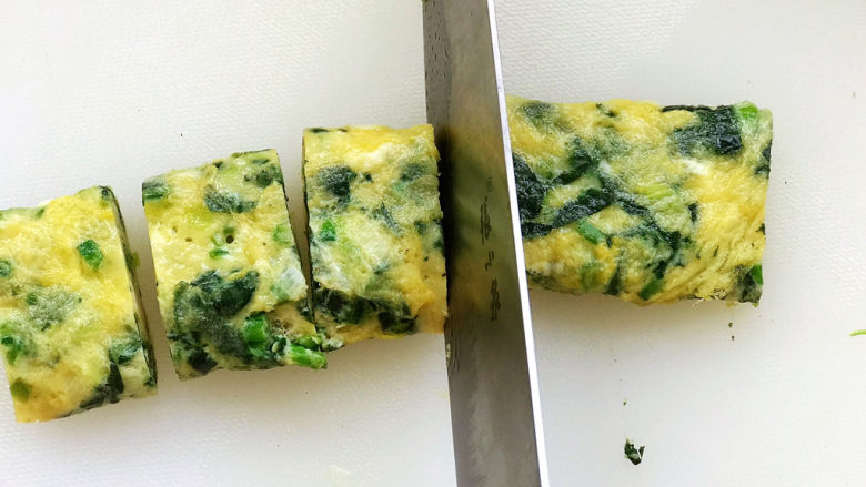 菠菜蛋卷,两个蛋卷煎好后,放在熟食砧板上切成小块;