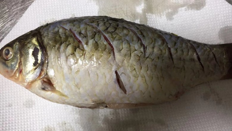 酱焖鲫鱼,
用厨房用纸擦干鲫鱼的表面水分,以免炸的过程炸锅