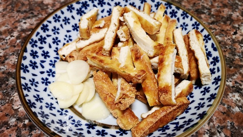 韭菜炒豆腐,将油豆腐切条,<a style='color:red;display:inline-block;' href='/shicai/ 2794'>大蒜</a>切片。