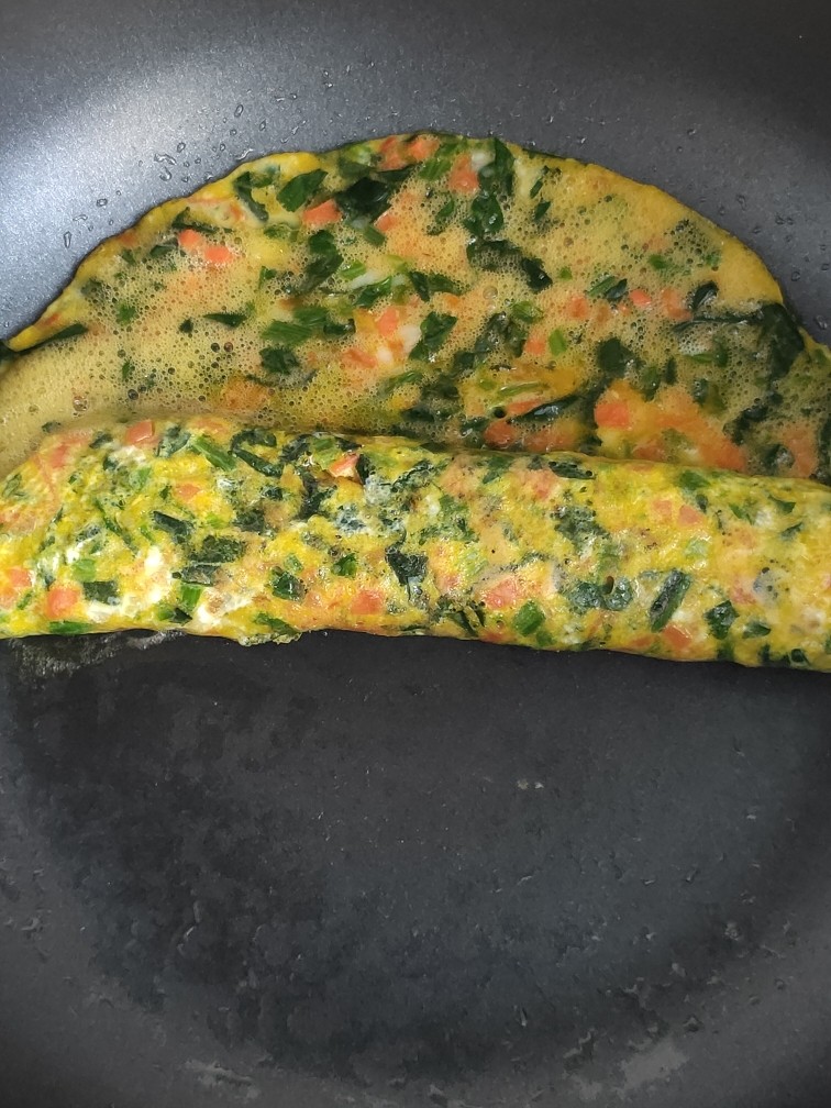菠菜蛋卷,从一侧卷起,卷到一半位置