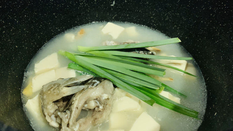 奶白鲫鱼豆腐汤,最后加入蒜苗叶,用大勺子舀汤汁,浇在蒜叶上,断生就可以了;