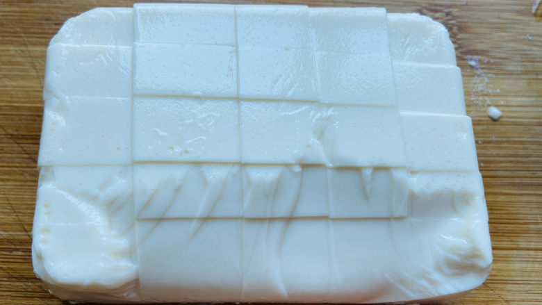 菠菜豆腐汤,撕去包装袋,倒扣在菜板上剪掉边上四个角再切小块