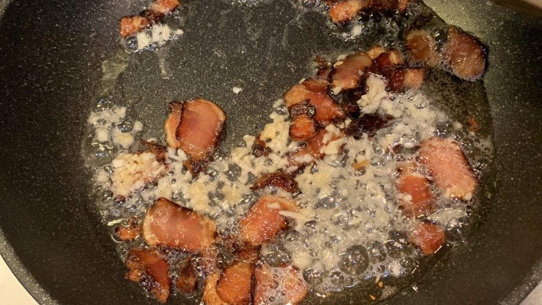 春笋炒腊肉,放入蒜粒,一起翻炒出香味,小火